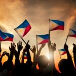 Group of People Waving Filipino Flags in Back Lit